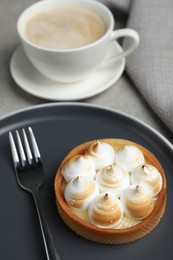 Tartlet with meringue served on grey table, closeup. Delicious dessert