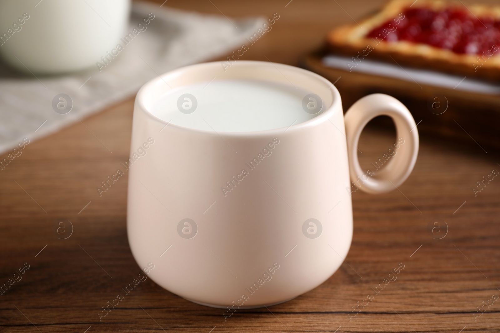 Photo of Cup of fresh milk on wooden table, closeup