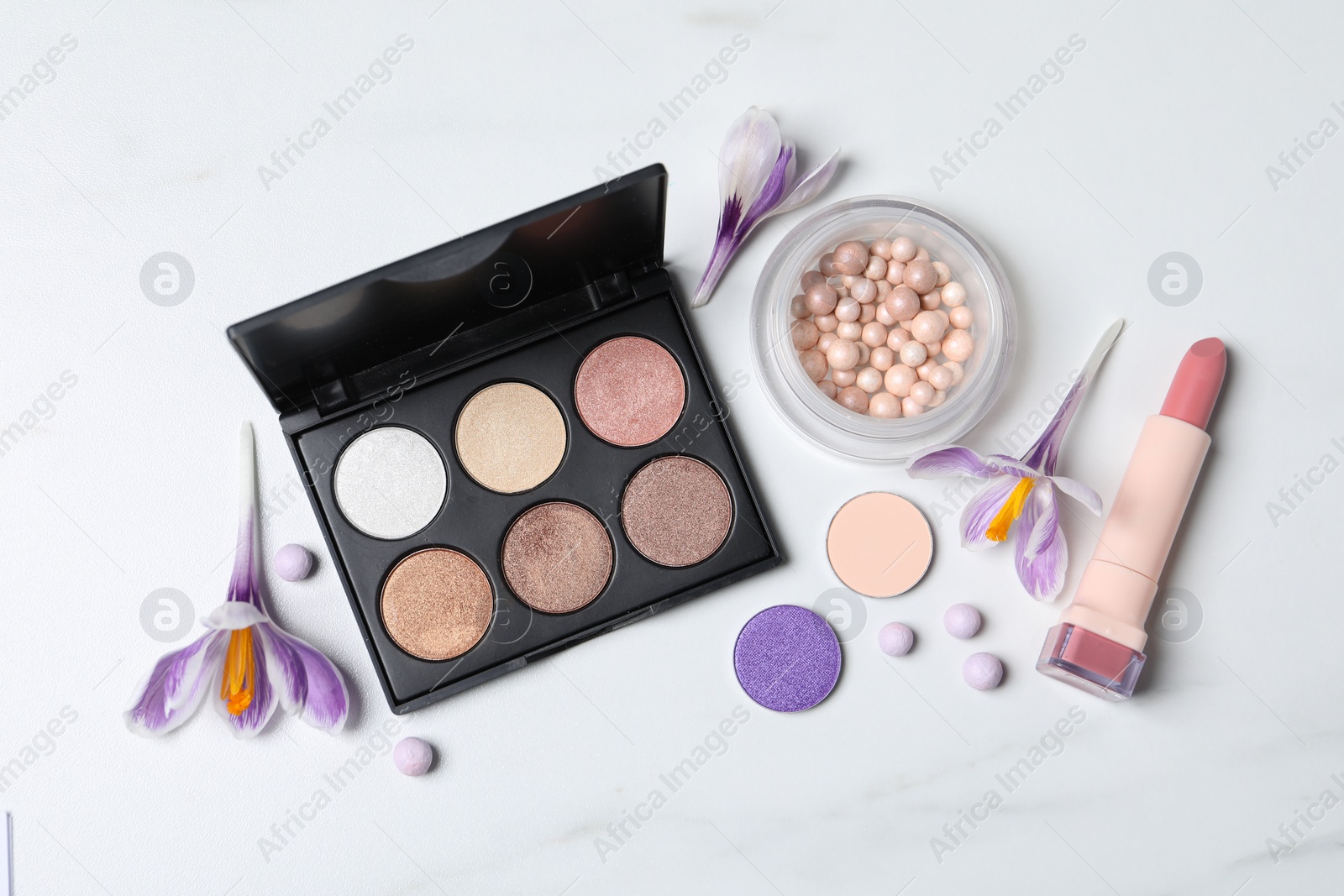 Photo of Flat lay composition with eyeshadow palette and beautiful crocuses on white marble table