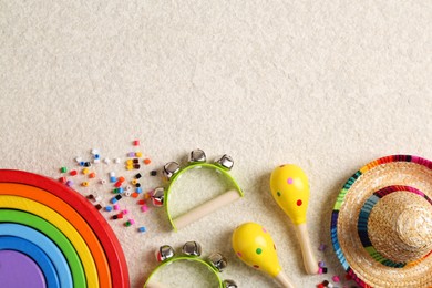 Photo of Baby song concept. Kids musical instruments and toys on beige carpet, flat lay. Space for text