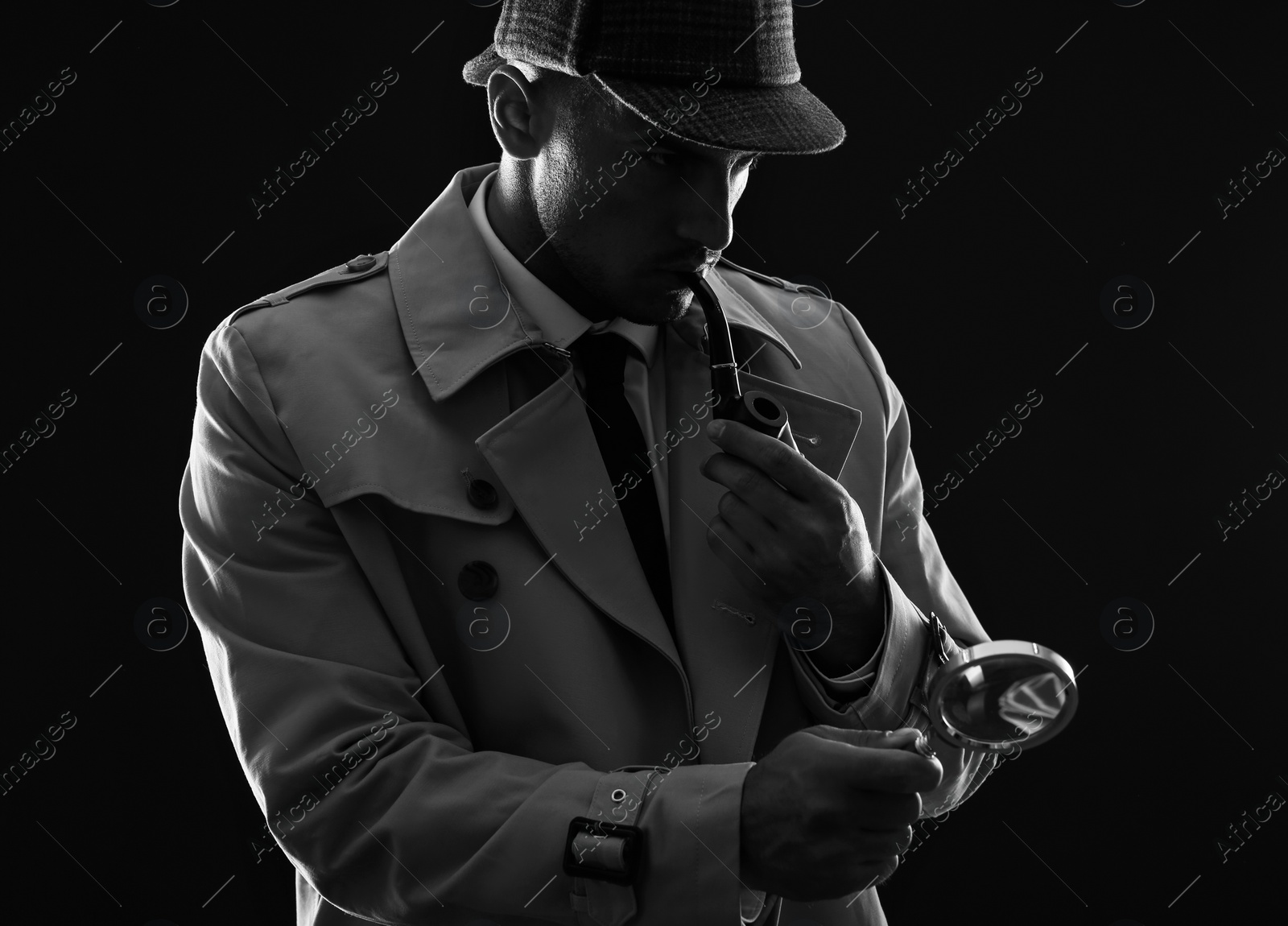 Photo of Old fashioned detective with magnifying glass smoking pipe on dark background, black and white effect