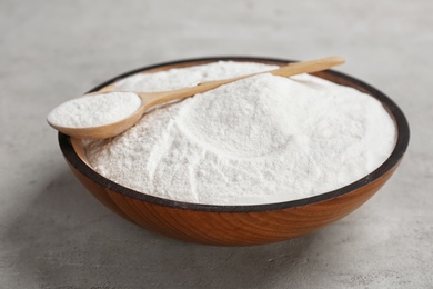 Photo of Bowl and spoon with baking soda on gray table