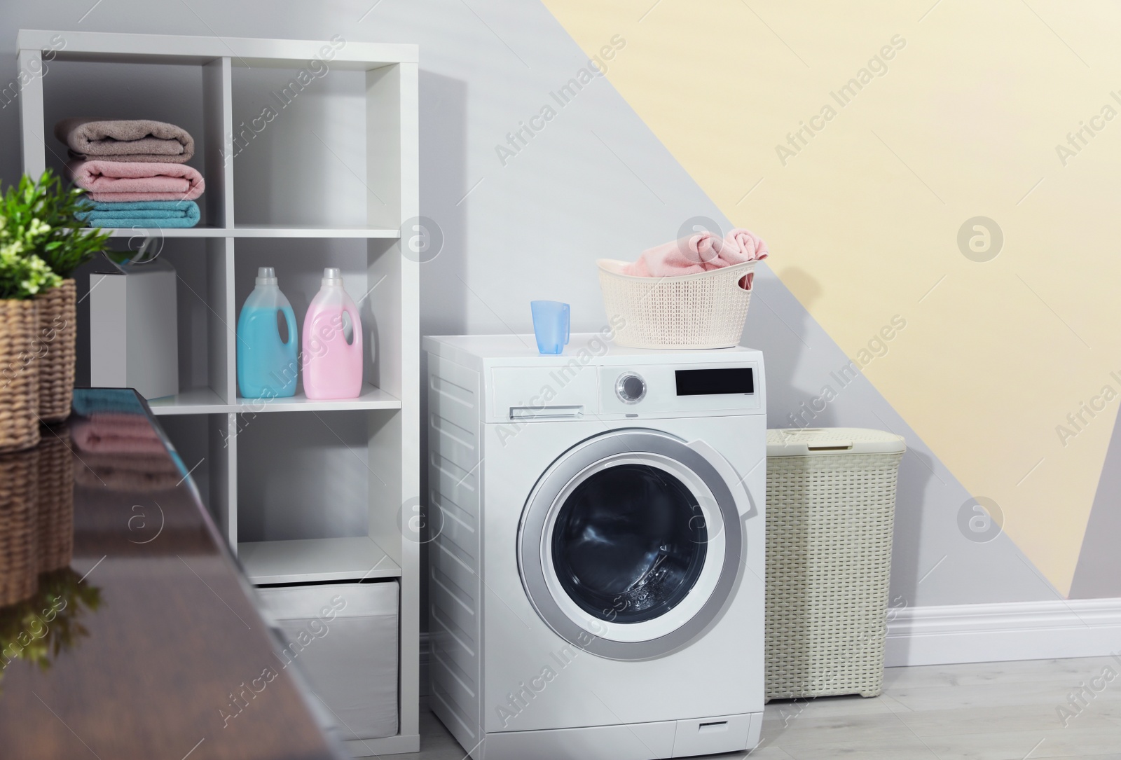 Photo of Modern washing machine in laundry room interior