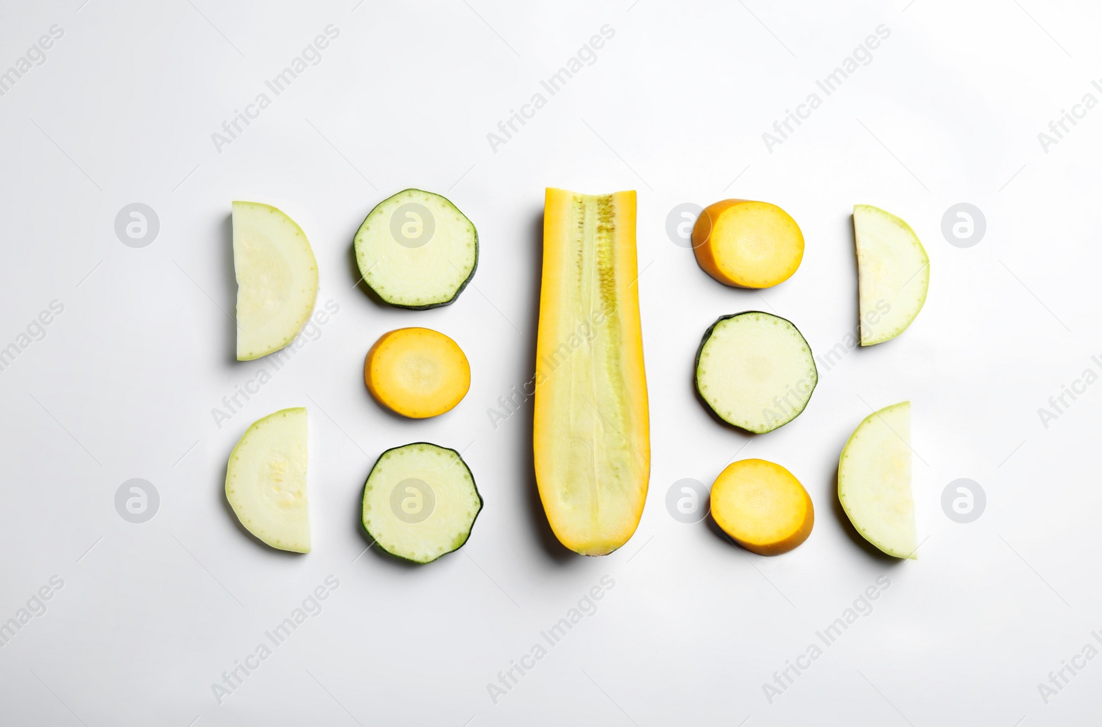 Photo of Fresh ripe cut zucchinis on white background, top view