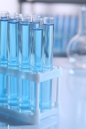 Photo of Test tubes with reagents in rack on table, closeup. Laboratory analysis