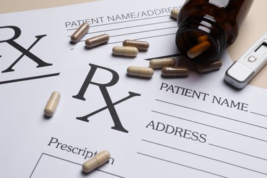 Photo of Medical prescription forms, pills, bottle and thermometer on beige background, closeup