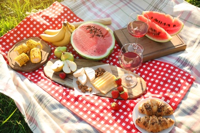 Picnic blanket with delicious food and drinks outdoors on sunny day