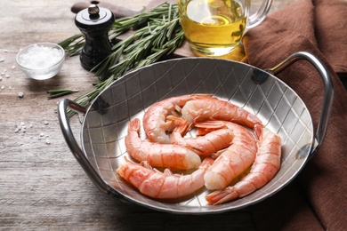 Photo of Metal dish with shrimps on wooden table