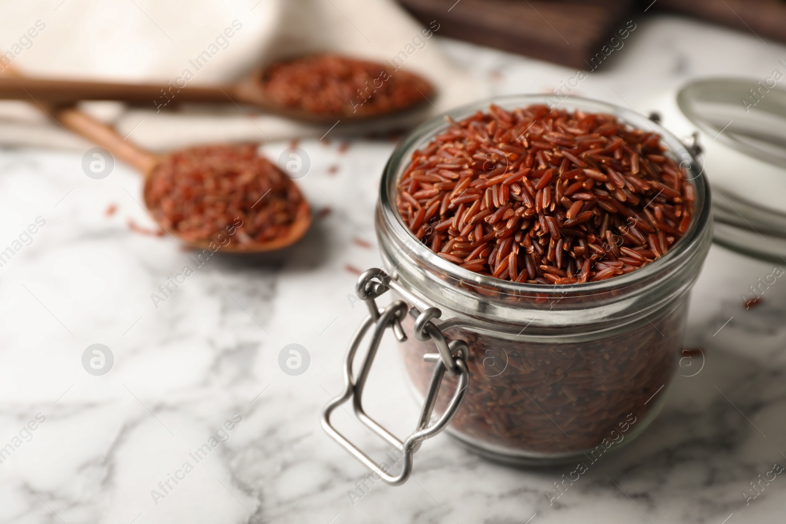 Photo of Brown rice in glass jar on table. Space for text