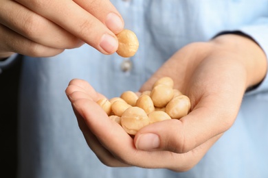 Photo of Woman holding shelled organic Macadamia nuts, closeup