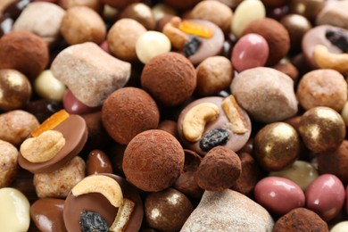 Photo of Different delicious chocolate candies as background, closeup