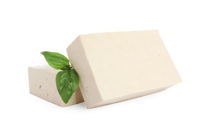 Photo of Blocks of delicious raw tofu with basil on white background