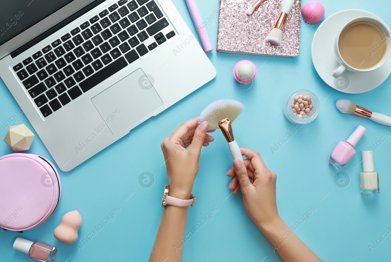 Photo of Young beauty blogger with brush and accessories on light blue background, top view