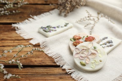 Photo of Scented sachets and flowers on wooden table