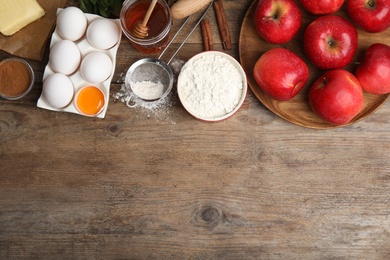 Photo of Traditional English apple pie ingredients on wooden table, flat lay. Space for text