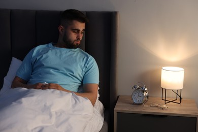 Photo of Frustrated man suffering from insomnia in bed