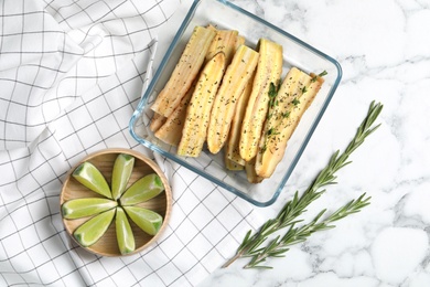 Photo of Flat lay composition with raw cut white carrot in  baking dish on white marble table