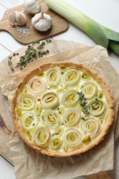 Photo of Tasty leek pie and products on white wooden table, above view