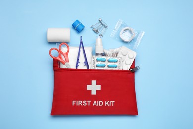 Photo of Flat lay composition with first aid kit on light blue background