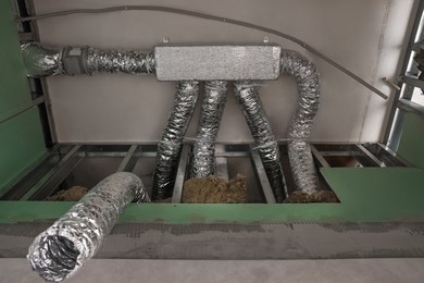Photo of New ventilation system on beige ceiling indoors
