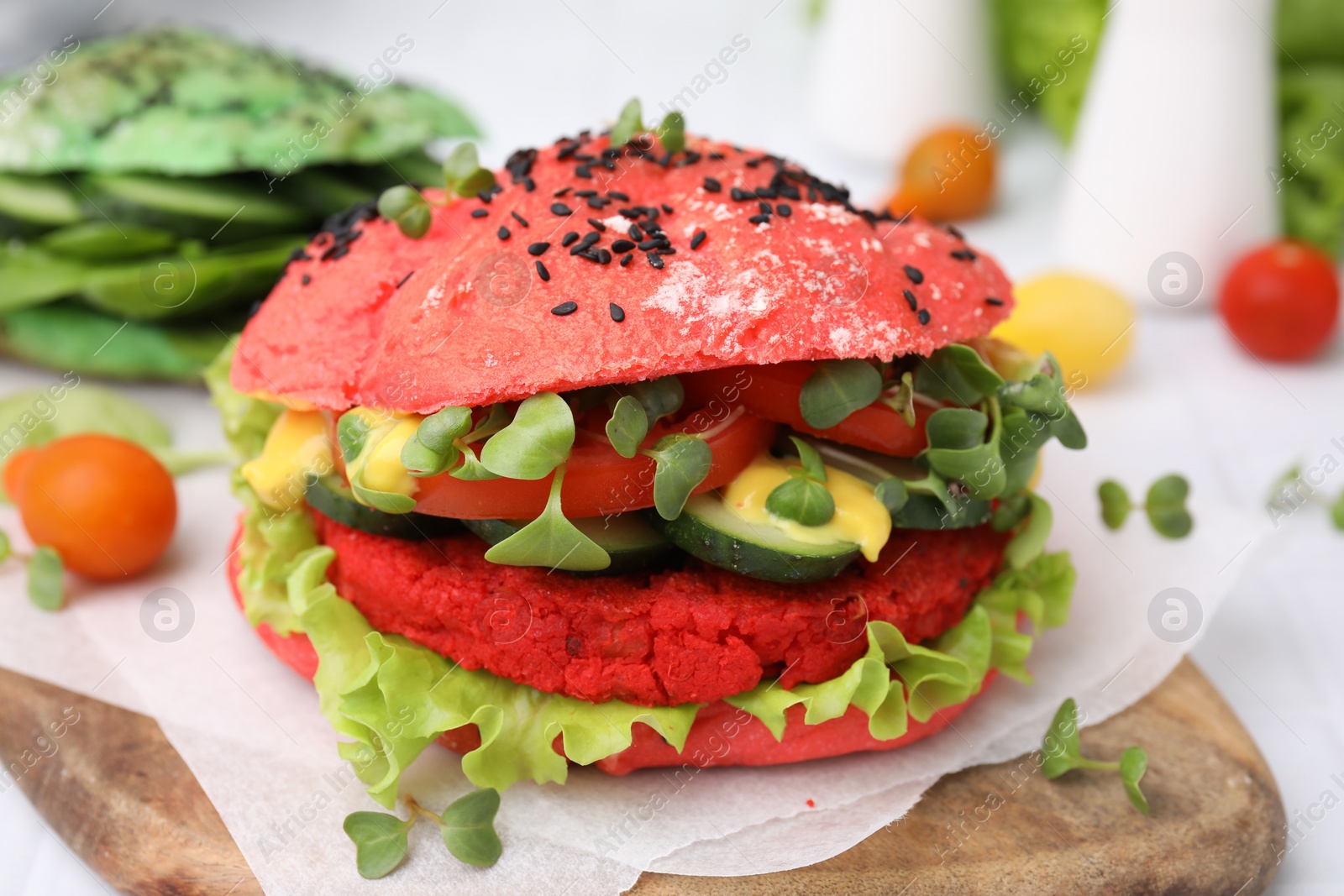 Tasty pink vegan burger with vegetables, patty and microgreens on white table, closeup Photo of Tasty pink vegan burger with vegetables, patty and microgreens on white table, closeup