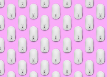 Image of Many white computer mouses on pink background, flat lay. Seamless pattern design