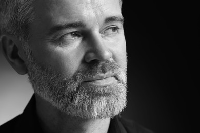 Photo of Portrait of handsome man on dark background, space for text. Black and white effect