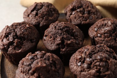 Photo of Board with delicious chocolate muffins on table, closeup
