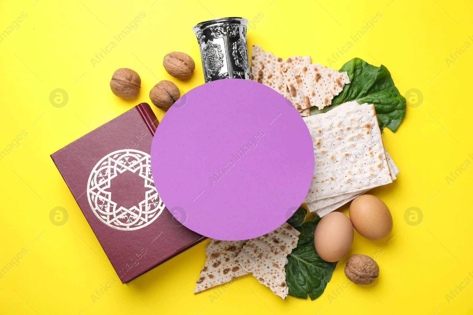 Photo of Frame made with symbolic Passover items and blank card on yellow background, space for text. Pesah celebration
