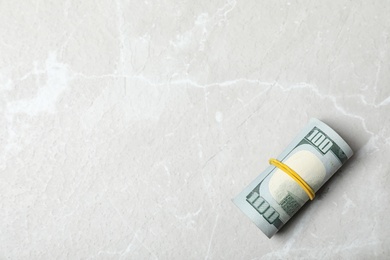 Rolled dollar banknotes and space for text on light background, top view