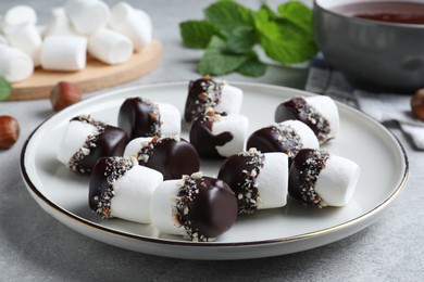 Photo of Delicious marshmallows covered with chocolate on light grey table