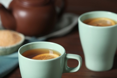 Photo of Cup of tea with lemon on table, closeup