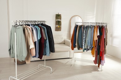 Photo of Racks with stylish clothes indoors. Fast fashion