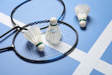 Photo of Feather badminton shuttlecocks and rackets on blue background