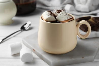 Photo of Cup of aromatic hot chocolate with marshmallows and cocoa powder on table, closeup