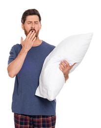 Photo of Tired man with pillow yawns on white background