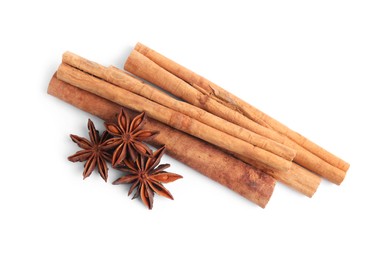 Photo of Aromatic cinnamon sticks and anise stars isolated on white, top view