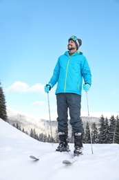 Photo of Man with ski equipment spending winter vacation in mountains