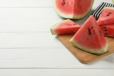Photo of Delicious fresh watermelon slices on white wooden table. Space for text