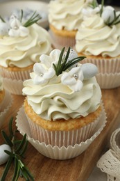Photo of Tasty Easter cupcakes with vanilla cream on table, closeup