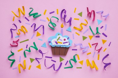Photo of Birthday party. Paper cupcake and confetti on pink background, flat lay
