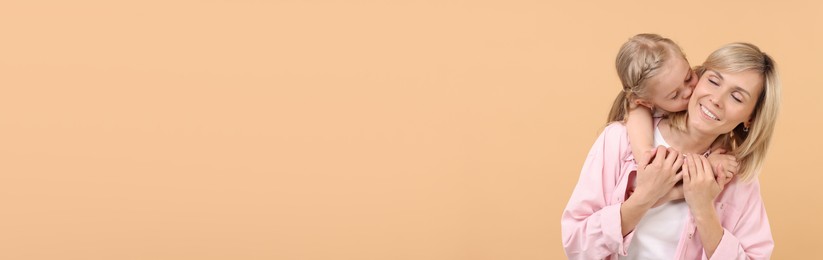Image of Happy mother and daughter on beige background, space for text. Banner design