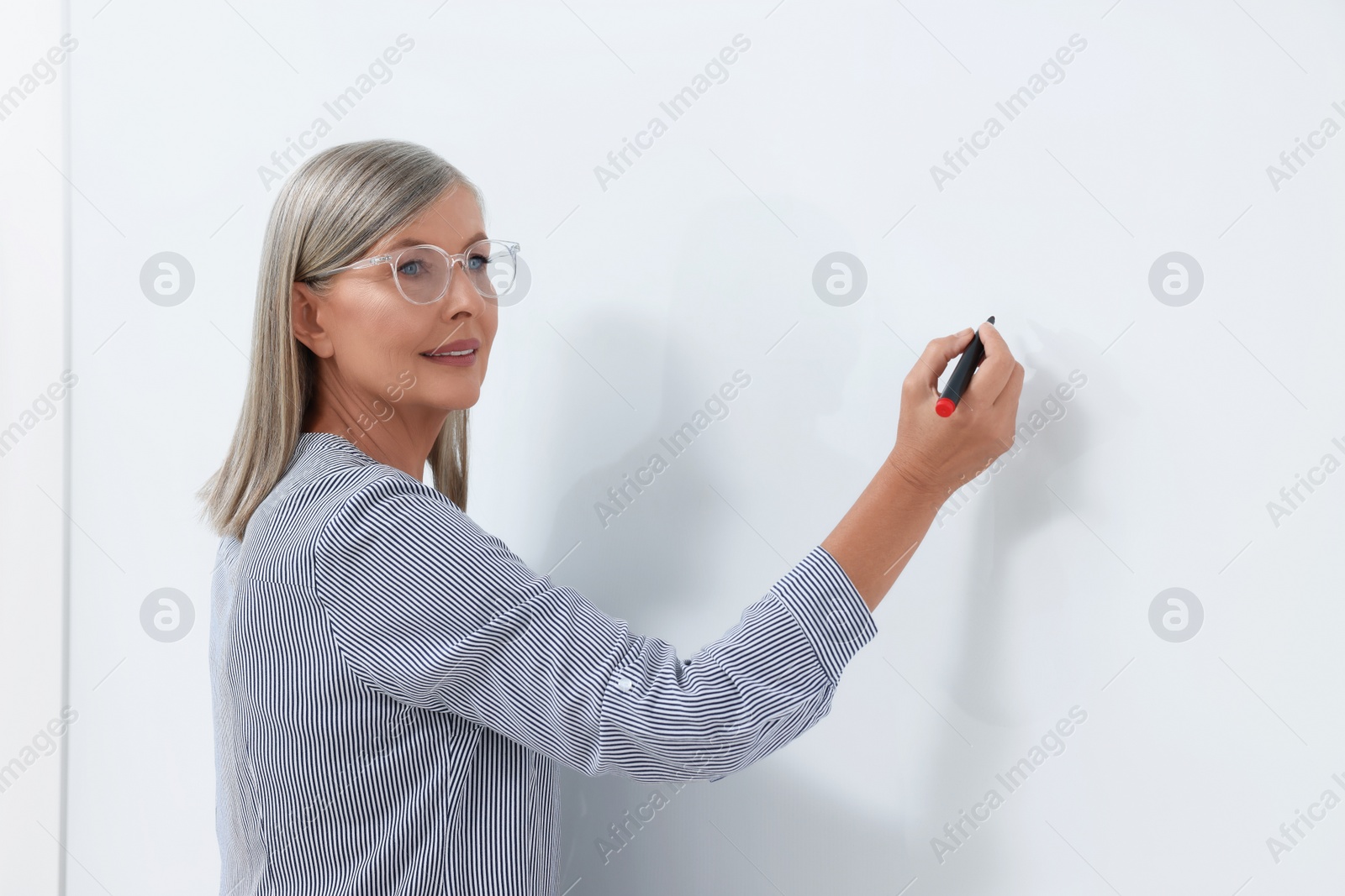 Photo of Portrait of professor explaining something at whiteboard indoors