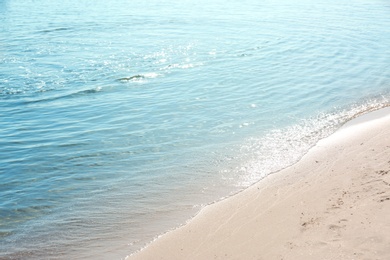 Photo of View of sea water and beach sand on sunny summer day