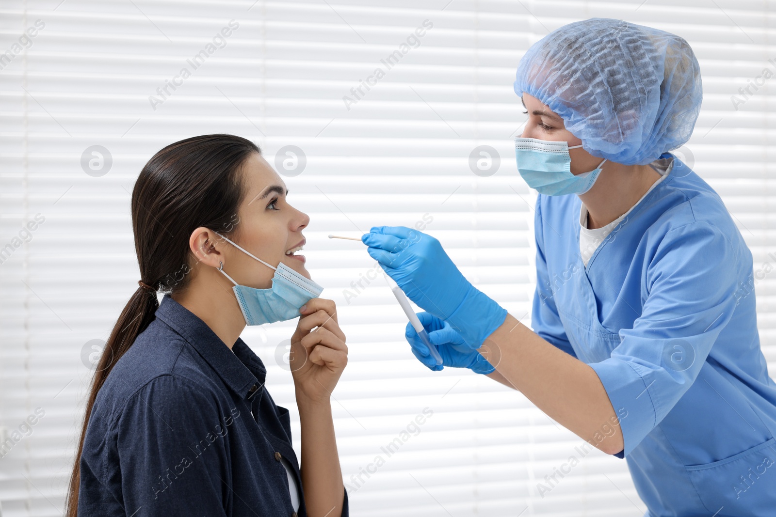 Photo of Laboratory testing. Doctor taking sample from patient's mouth with cotton swab in hospital
