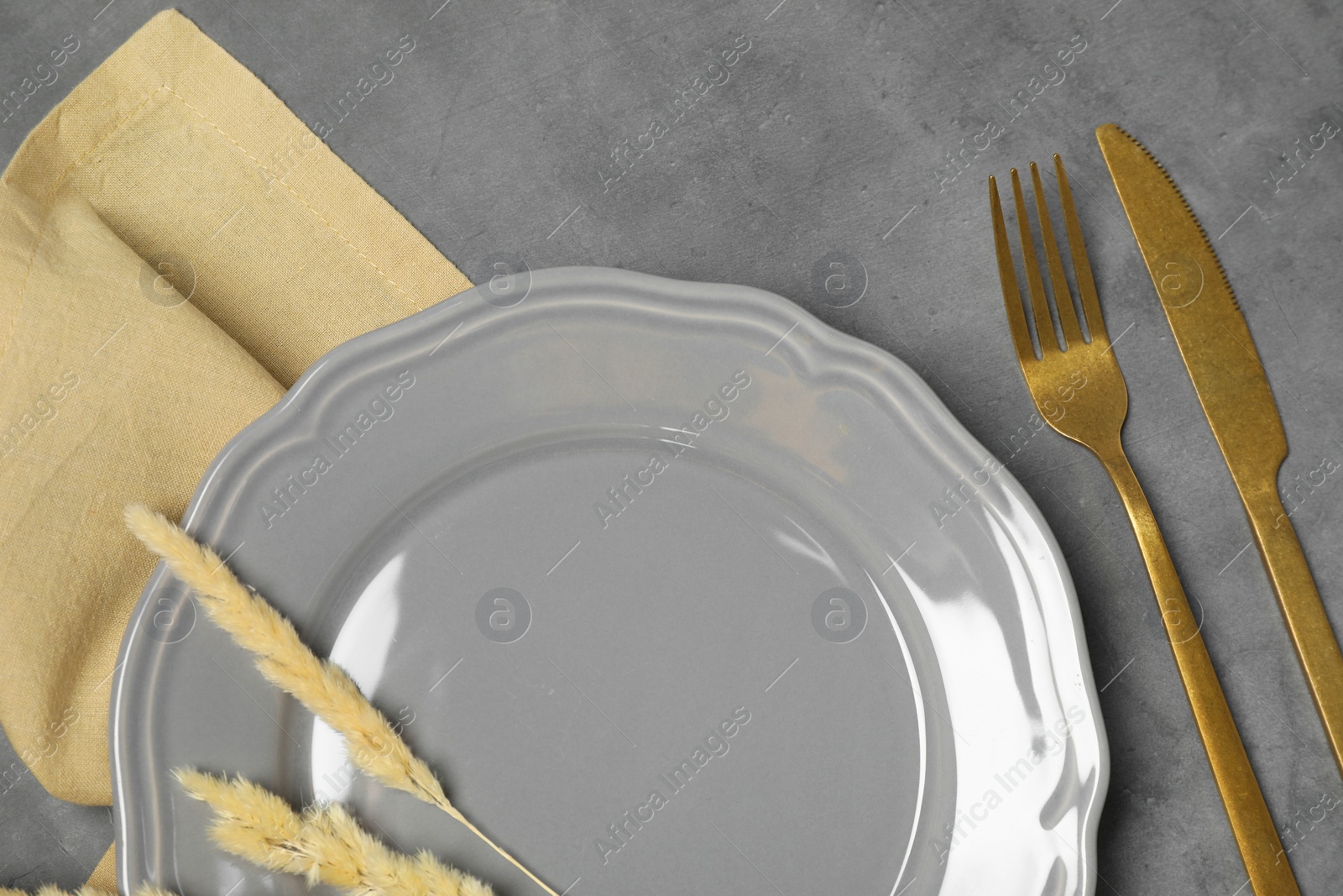 Photo of Stylish setting with elegant cutlery on dark grey table, top view