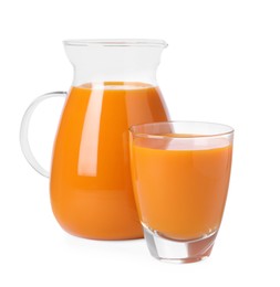 Photo of Glass and pitcher of carrot juice on white background
