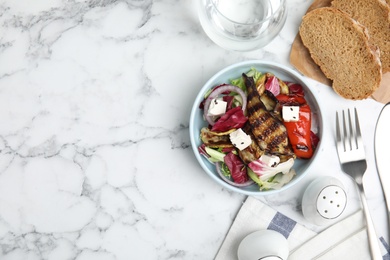 Photo of Delicious salad with roasted eggplant, feta cheese and chia seeds on white marble table, flat lay. Space for text