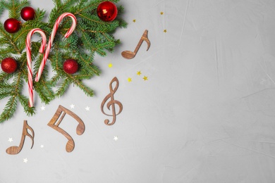 Photo of Flat lay composition with Christmas decor, wooden music notes and space for text on grey background