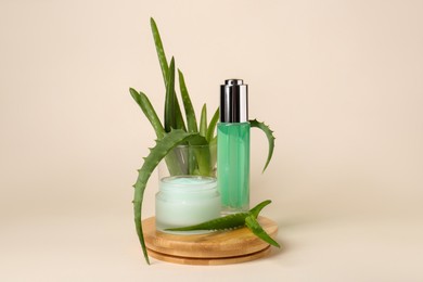 Photo of Cosmetic products and fresh aloe on beige background
